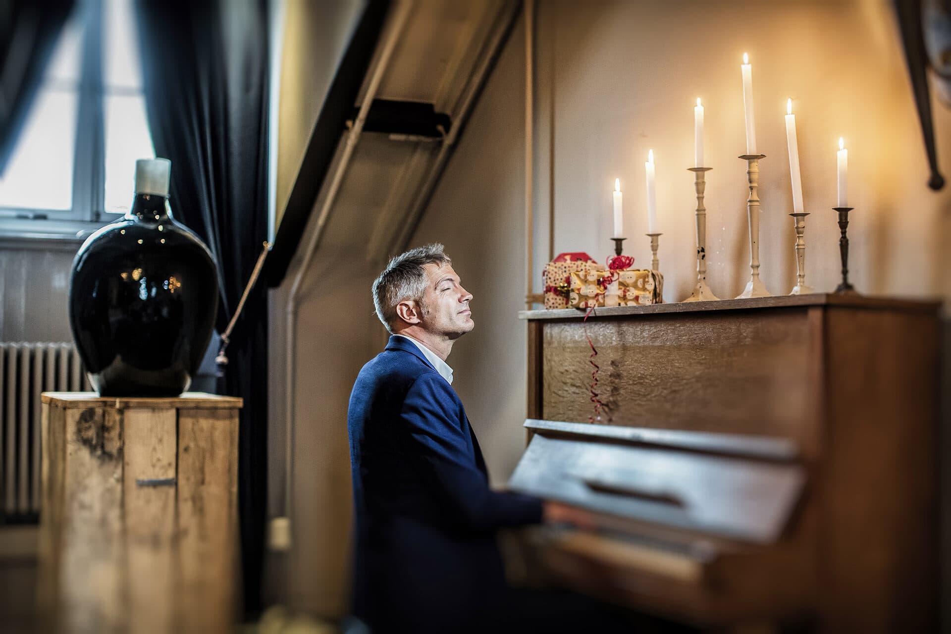 Gerald Troost achter de piano bij kaarslicht tijdens de CD-shoot