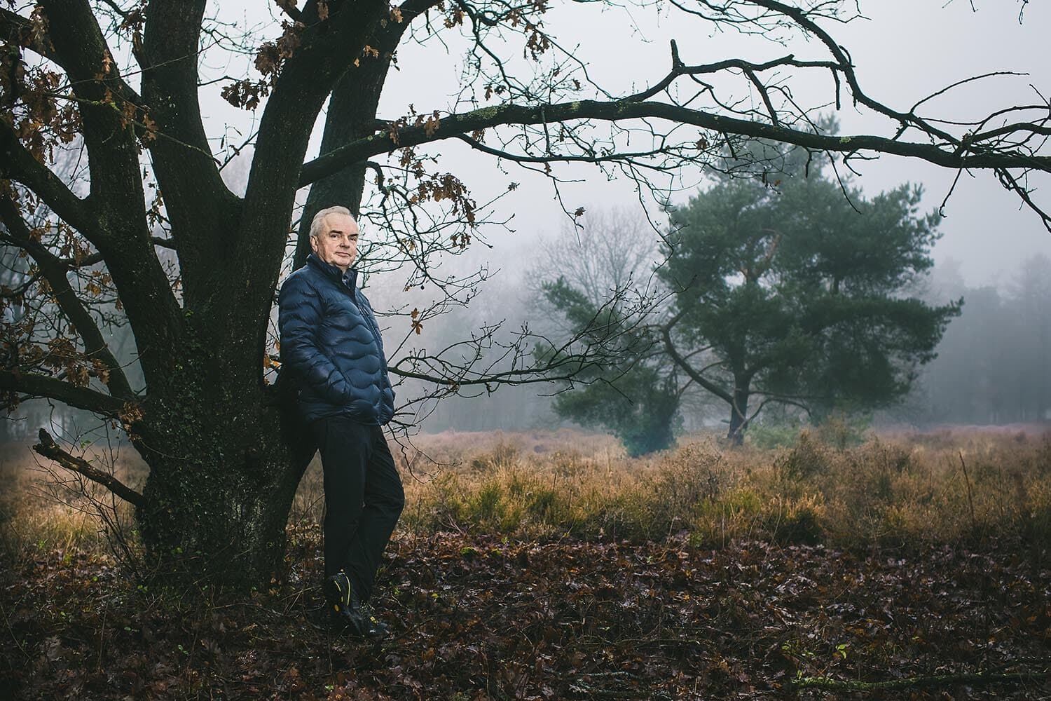 Portret van Steven van Eijck onder een oude eik in de mist
