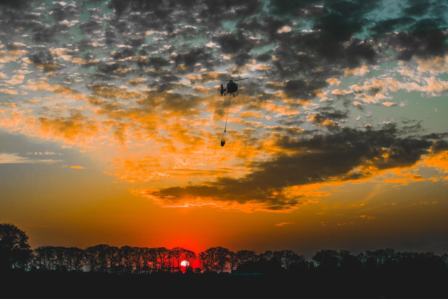 Helikopter met bambi bucket, gefotografeerd vanuit de lucht